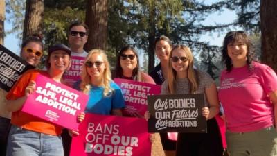 People canvassing for Planned Parenthood, holding signs that say "Bans Off Our Bodies"