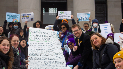 Advocates hold a giant banner of the "unfunded budget" on the Washington State Legislature's steps.